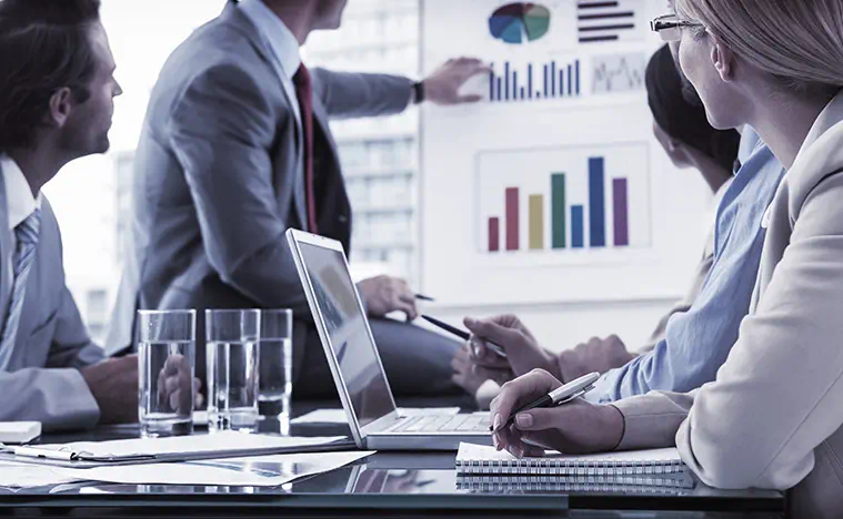 Property Management Services Budget A group of people in a meeting discussing financial reports.