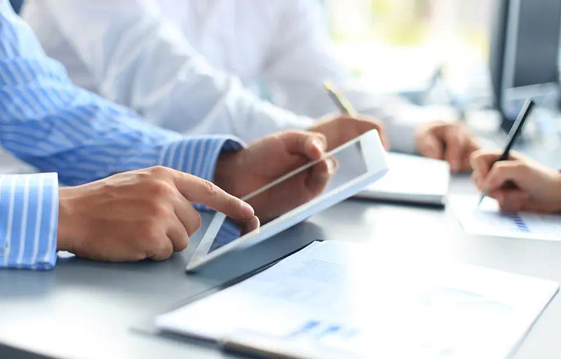 Lease Execution Several business people filling out a report on their tablet.