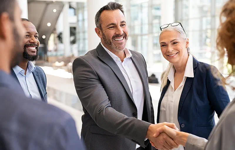 Lease Negotiation A group of business people shaking hands with another group.