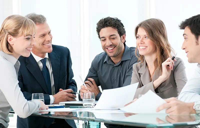 Seller Representation A group of business people discussing a contract in a meeting room.