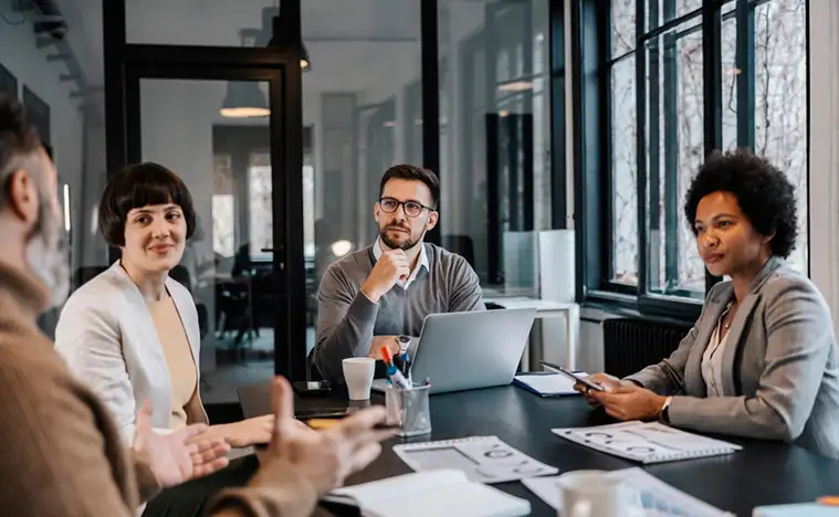 A group of business people meet in a conference room.